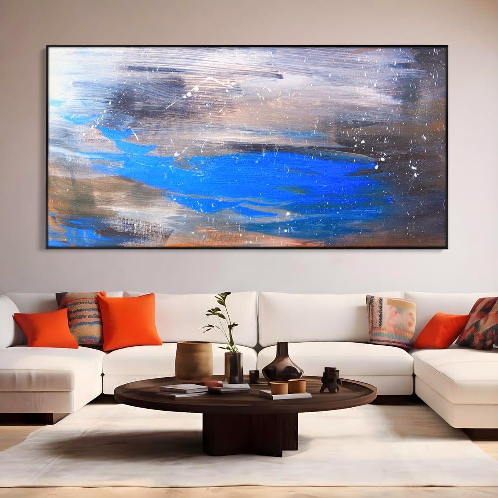 Tablou canvas cu pictura abstracta cu pete albastre, in rama de aluminiu negru, pe perete intr-un living
